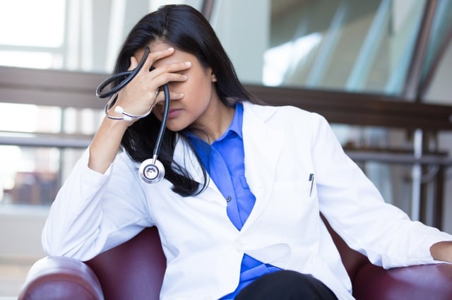 A healthcare professional exhibiting signs of stress