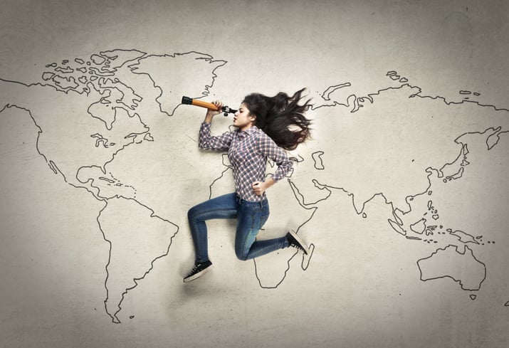 woman laying on a world map with a telescope signifying job search
